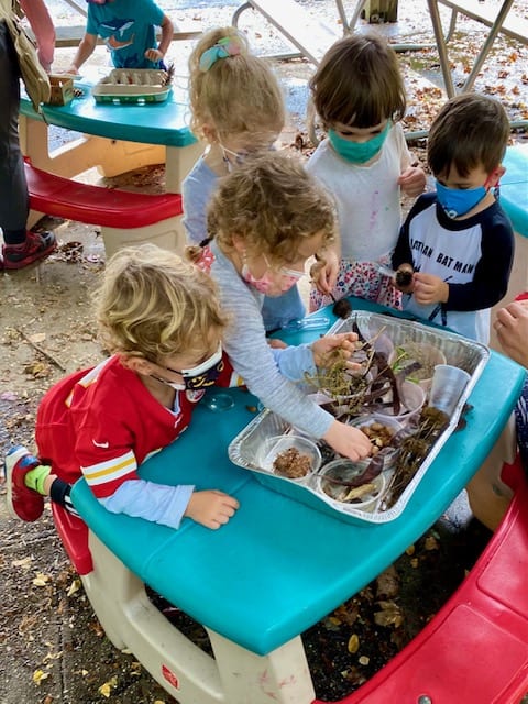 Toddlers working on an outdoor craft at a Sheldrake birthday party.