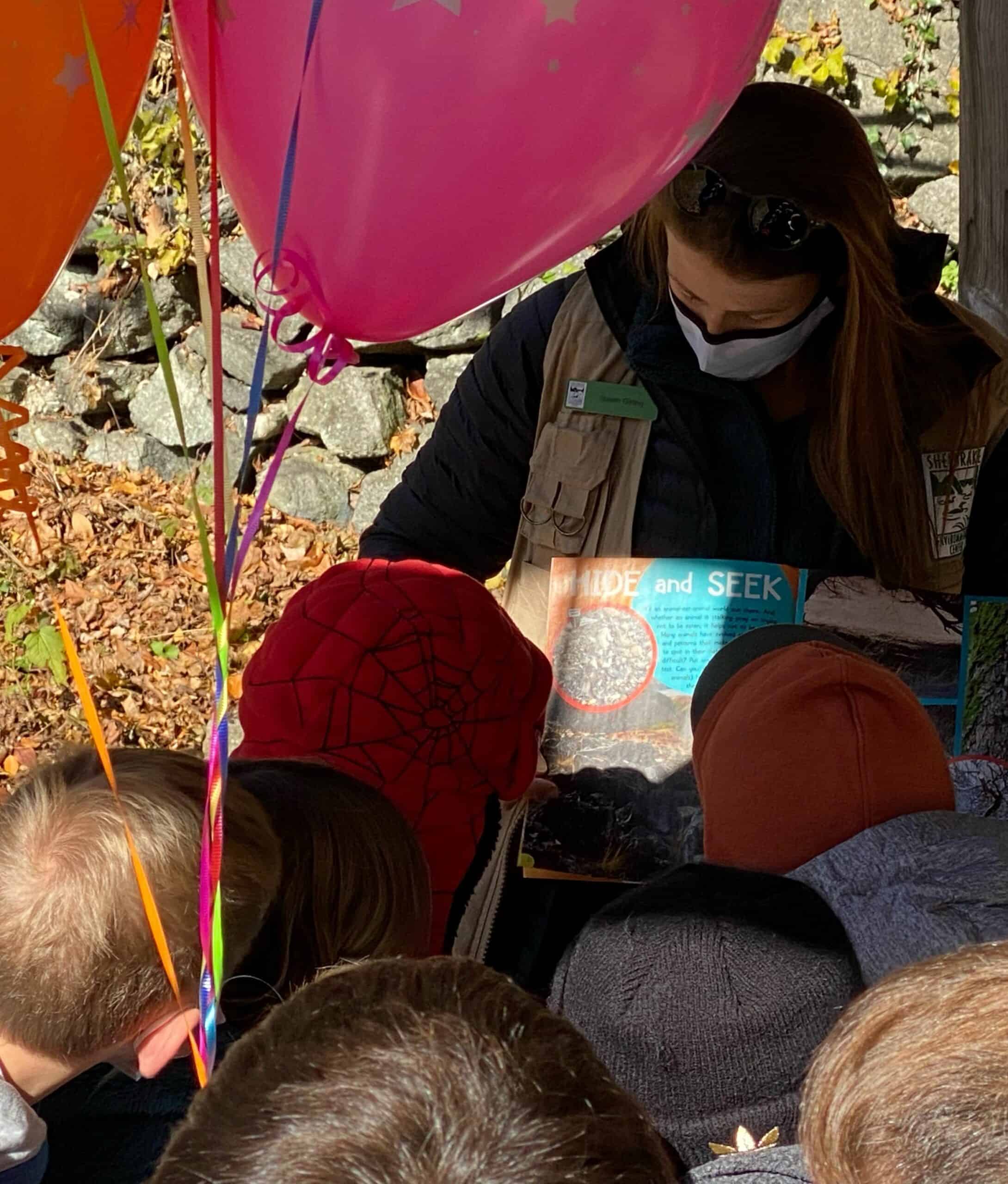 Children being read a story at a Sheldrake birthday party with balloons.