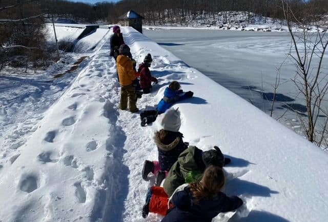 Kids at Sheldrake looking over dam in the snow