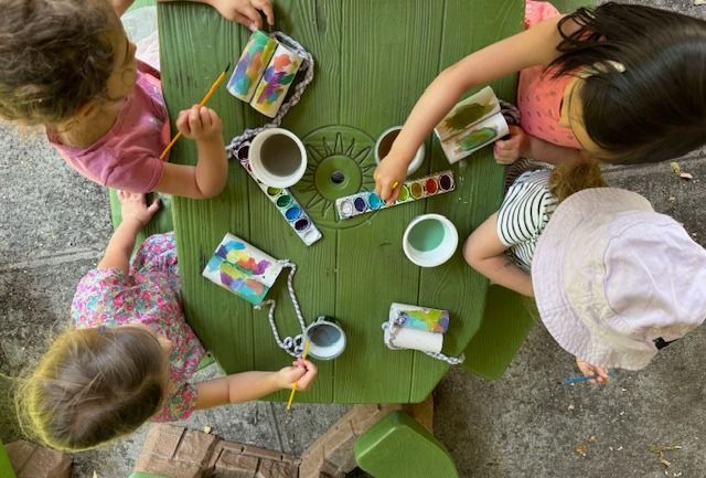 bird's-eye view of children making a craft at a table